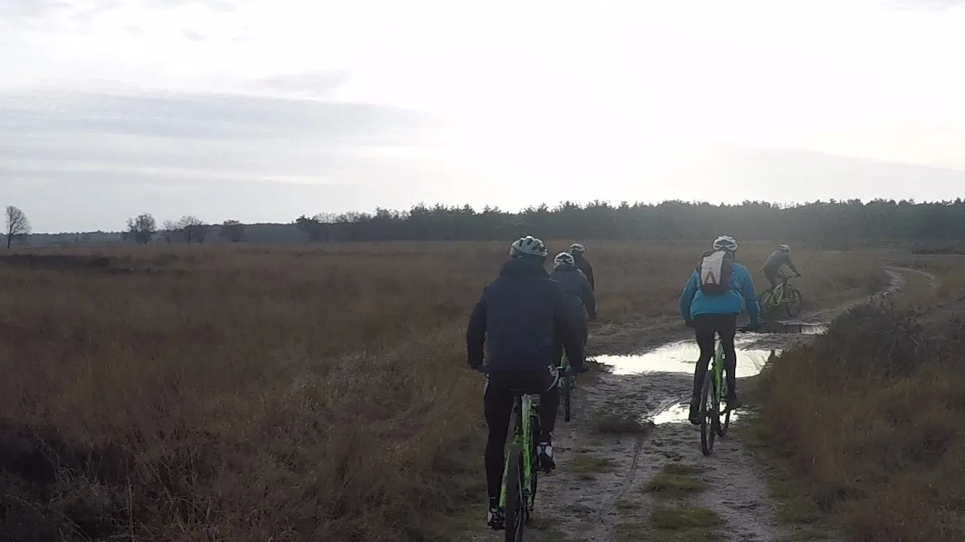 Mountainbikers op een zandpad over de heide
